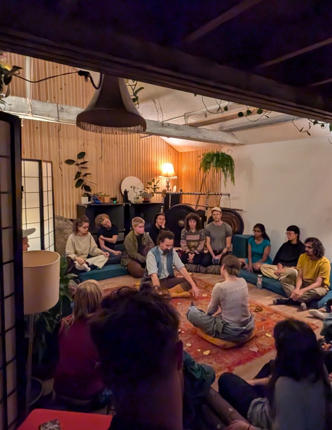 Attendees sit in a circle in the Gong Library during the Book of Light launch and participatory card readings.