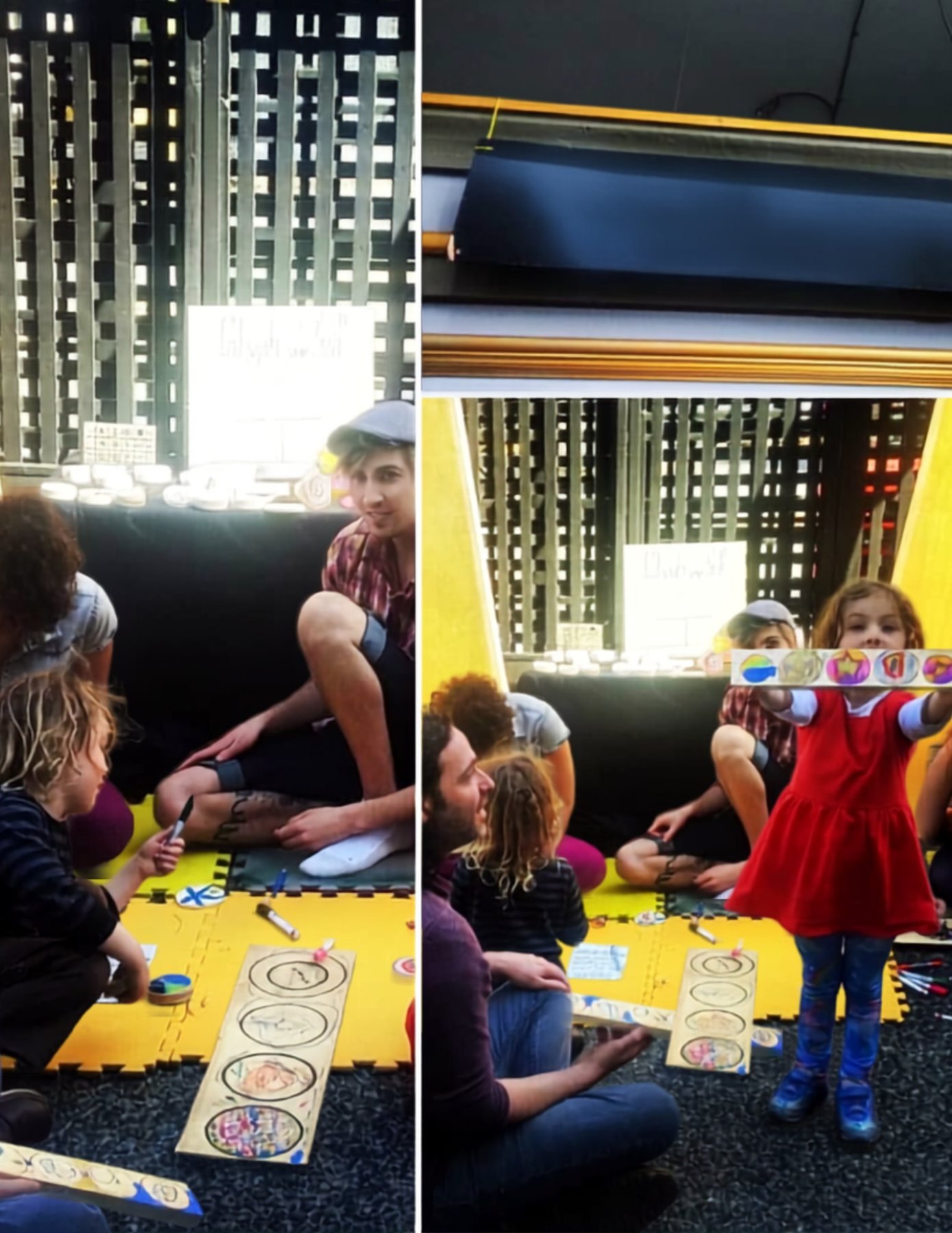 Participants seated together making glyphs while a child holds up a completed painted wooden glyph panel.