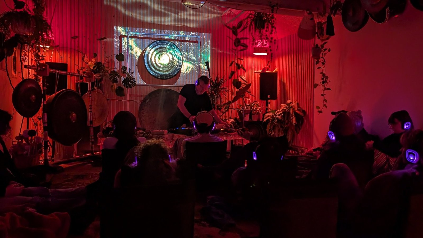 Michael Red performs at a table in the Gong Library while audience members listen through wireless headphones.