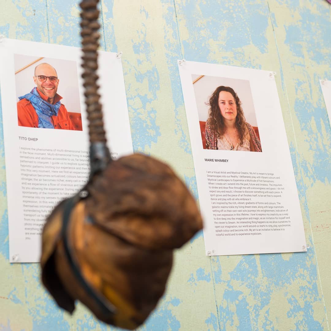 Artist statement sheets pinned to a blue-painted wall